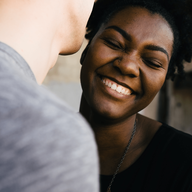 Man whispering in woma's ear to illustrate why sharing is so important to building relationships. Photo credit: Tanja Heffner