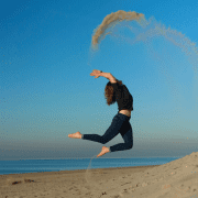 Woman jumping on beach showing ways to boost your energy